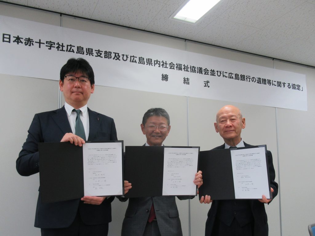 協定締結書を手にする各団体の代表者